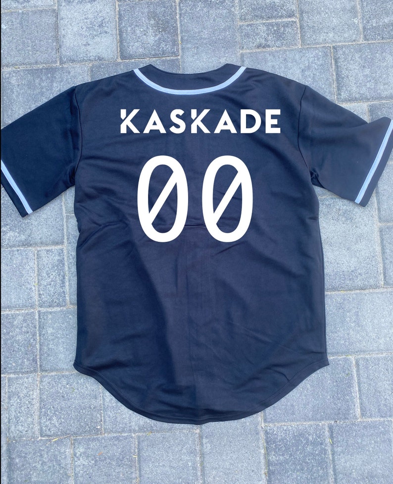 May include: Black baseball jersey with white trim and the text "KASKADE 00" on the back.