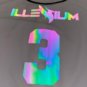 May include: A white baseball jersey with a black collar and a reflective iridescent logo that says "ILLESIUM" and the number "3" on the back.