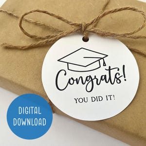May include: White gift tag with a black graduation cap and the text "Congrats! You Did It!"