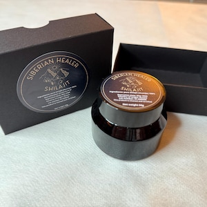May include: A black box with the text "Siberian Healer Shilajit" on the front. The box contains a black jar of Shilajit, a natural substance.