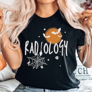 May include: Black t-shirt with a white graphic of a spider web, bats, and a moon with the text "RADIOLOGY" on it.