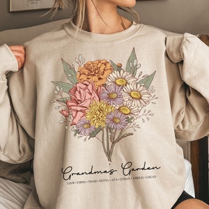 May include: A beige sweatshirt with a floral design and the text "Grandma's Garden" with a list of names below.
