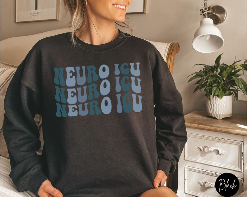Pode incluir: Camisola de moletom preta com um gr&aacute;fico de estilo retr&ocirc; que diz "Neuro ICU" repetido tr&ecirc;s vezes em azul e turquesa.