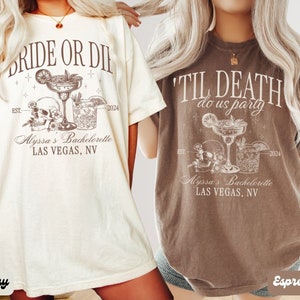 May include: Two t-shirts with a bachelorette party theme. The ivory t-shirt says "Bride or Die" with a skull and two cocktails. The espresso t-shirt says "Til Death Do Us Party" with a skull and two cocktails. Both shirts say "Alyssa's Bachelorette Las Vegas, NV" and "Est. 2024".