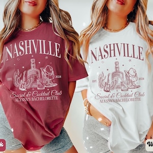 K&ouml;nnte beinhalten: Zwei Frauen tragen T-Shirts mit einem wei&szlig;en Grafikdesign, auf dem "Nashville Social & Cocktail Club Alyssa's Bachelorette" steht, sowie eine Zeichnung einer Flasche Alkohol, eines Glases, einer Gitarre, eines Cowboyhuts und Cowboy-Stiefeln. Das T-Shirt links ist ziegelrot und das T-Shirt rechts ist wei&szlig;.