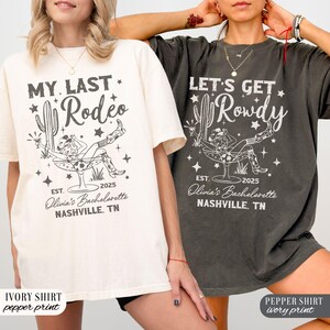 May include: Two white t-shirts with black text and graphics. The first shirt says "My Last Rodeo" with a cactus and a woman in a cowboy hat sitting in a margarita glass. The second shirt says "Let's Get Rowdy" with a cactus and a woman in a cowboy hat sitting in a margarita glass. Both shirts say "Est. 2025 Olivia's Bachelorette Nashville, TN".