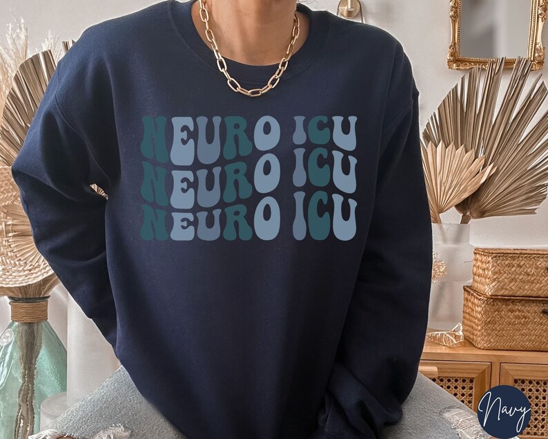 Pode incluir: Camisola azul marinho com o texto "NEURO ICU" repetido tr&ecirc;s vezes em uma fonte retro ondulada. O texto est&aacute; em tons de azul e verde.