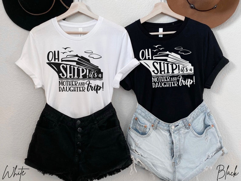 May include: Two t-shirts featuring a cruise ship graphic and the text "Oh Ship! It's a Mother and Daughter Trip!" One shirt is white with black text and the other is black with white text.