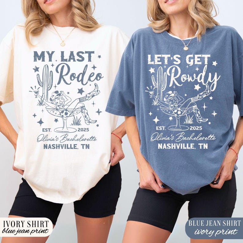 May include: Two t-shirts with a bachelorette party theme. The ivory shirt has a blue jean print with the text "My Last Rodeo" and the blue jean shirt has an ivory print with the text "Let's Get Rowdy". Both shirts feature a graphic of a woman sitting in a margarita glass with a cactus and stars.