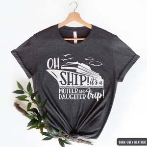 May include: Dark grey heather t-shirt with a white graphic of a cruise ship and the text "Oh Ship! It's a Mother and Daughter Trip!"