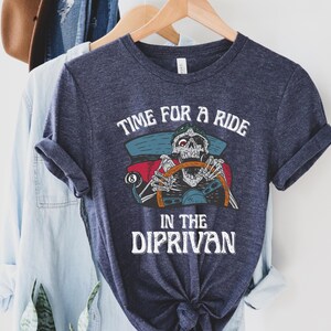 May include: A dark blue t-shirt with a skeleton driving a car and the text "Time for a ride in the Diprivan".