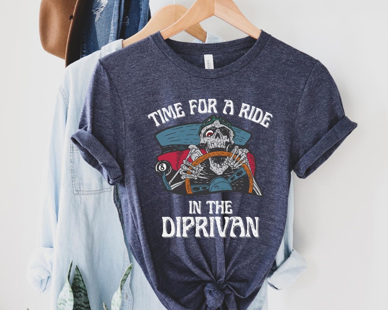 May include: A dark blue t-shirt with a skeleton driving a car and the text "Time for a ride in the Diprivan".