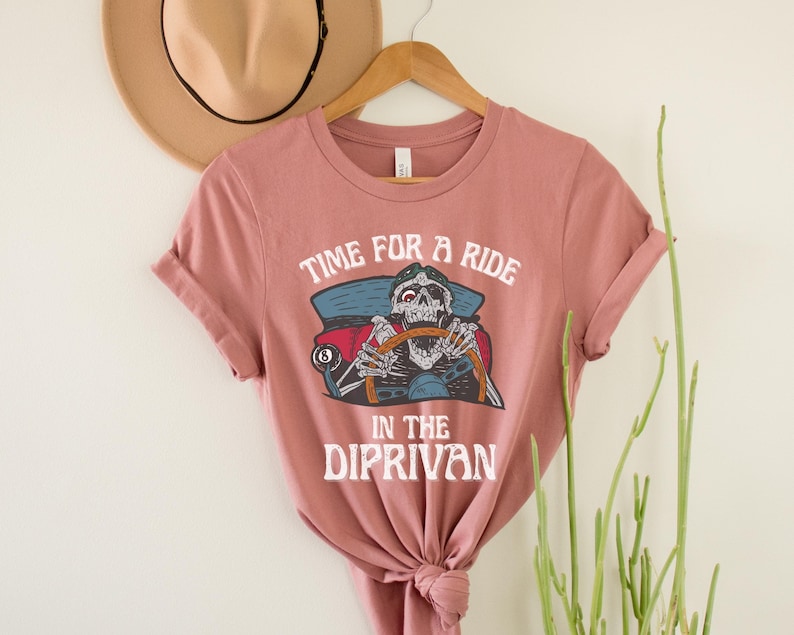 May include: A pink t-shirt with a skeleton driving a car and the text "Time for a ride in the Diprivan".