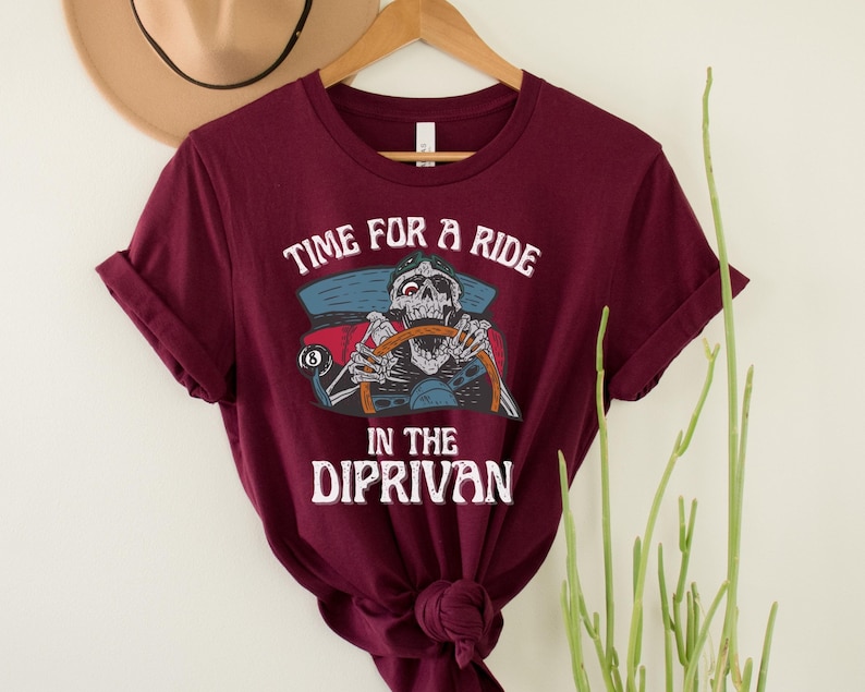 May include: A maroon t-shirt with a graphic of a skeleton driving a car with the text "Time for a ride in the Diprivan".