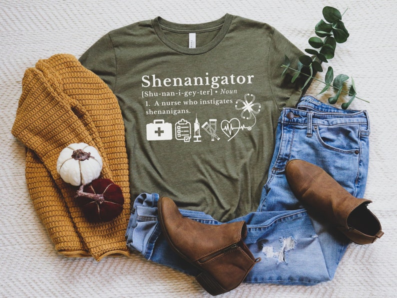 May include: A green t-shirt with the text "Shenanigator [Shu-nan-i-gey-ter]. Noun 1. A nurse who instigates shenanigans." and a variety of medical symbols.