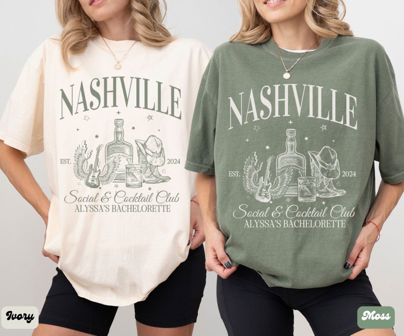 K&ouml;nnte beinhalten: Zwei T-Shirts mit einem grafischen Design, das den Text "Nashville" und eine Zeichnung einer Flasche, einer Gitarre und Cowboystiefeln zeigt. Der Text "Social & Cocktail Club" und "Alyssa's Bachelorette" sind ebenfalls auf den Shirts enthalten. Die Shirts sind in Elfenbein und Moosgr&uuml;n.