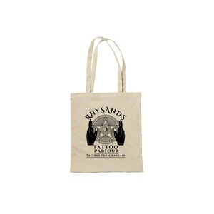 May include: A beige canvas tote bag with black text and a graphic design. The text reads "Rhysands Tattoo Parlour Tattoos for a Bargain". The graphic is a five-pointed star with a circle in the center and two hands holding the star.