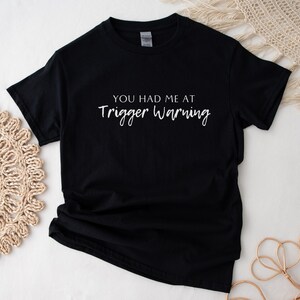 May include: Black t-shirt with white text that reads "You had me at trigger warning."