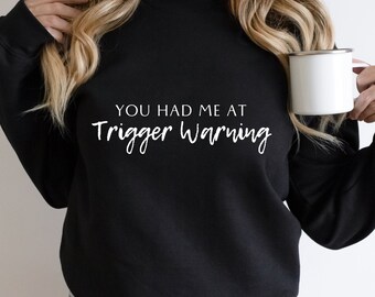 May include: Black sweatshirt with white text that reads "You had me at trigger warning."