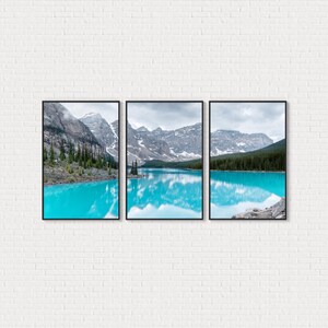 May include: A triptych of framed landscape art featuring a vibrant turquoise lake reflecting snow-capped mountains under a cloudy sky. The artwork showcases a serene natural scene with lush green trees along the lake's edge.
