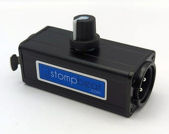 May include: A black rectangular stompbeat.com audio device featuring a single black rotary knob with a white indicator line on top. The unit has a blue and white rectangular label with the text stompbeat.com and a circular XLR input port on the side.