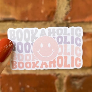 Sticker bookaholic smiley roze paars pastel vrolijke boekenwurm leesgrage boek liefde lezen waterfles laptop plakboek bullet journal