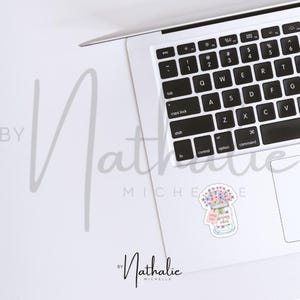 Może przedstawiać: Aquarela przedstawiająca słoik wypełniony kolorowymi kwiatami i etykietą z napisem "Spread happy vibes". Ilustracja jest wydrukowana na białej naklejce.