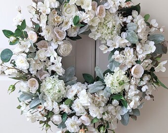 Lente witte elegante krans met appelbloesems, kersenbloesems, hortensia voor de voordeur. Paaskrans, modern landhuis, moederdag