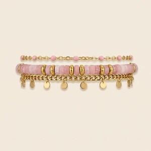 May include: A set of four bracelets in shades of pink and gold. The bracelets feature pink beads, gold chains, and gold disc charms. The bracelets are stacked together, showcasing the different designs and textures.