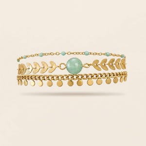 May include: Three-layer gold-toned bracelet set. The top layer features small turquoise beads, the middle layer has leaf-shaped charms, and the bottom layer has small circular charms. A large, round, green stone is centered on the middle layer.