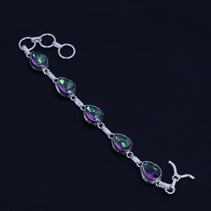 Könnte beinhalten: Ein silbernes Armband mit fünf tropfenförmigen, schillernden Edelsteinen. Das Armband hat einen Karabinerverschluss.