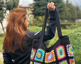 May include: A black crochet tote bag with colorful square patches. The bag has a large capacity and is perfect for carrying everyday essentials.