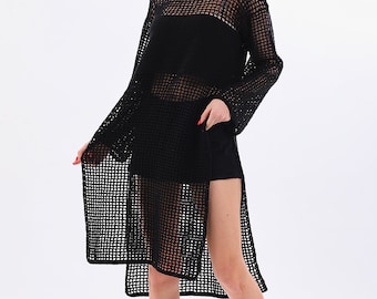 May include: A black, open-weave dress with long sleeves and a high side slit. The dress is paired with black shorts and sandals. The model is wearing black sunglasses. The outfit is set against a white background.