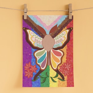 May include: A colorful art print featuring a moth with butterfly-like wings. The wings are decorated with floral patterns and rainbow colors, set against a rainbow background. Red flowers and green leaves are at the bottom.