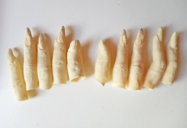 May include: Ten realistic-looking, pale, flesh-colored, fingertip props. The fingertips are made of a soft, pliable material and are designed to look like human fingers.