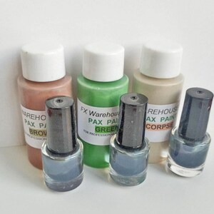 May include: Four small bottles of paint, two with black caps and two with white caps. The bottles are labeled with the text "FX Warehouse Pax Paint Green" and "REHOUSE AX PAINT CORPSE".