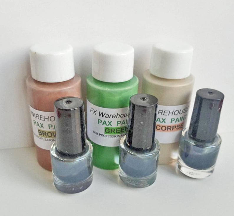 May include: Four small bottles of paint, two with black caps and two with white caps. The bottles are labeled with the text "FX Warehouse Pax Paint Green" and "REHOUSE AX PAINT CORPSE".