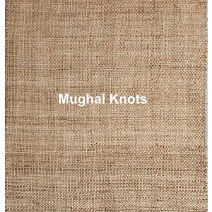 K&ouml;nnte beinhalten: Nahaufnahme eines Naturfaser-Teppichs mit gewebter Struktur. Der Teppich ist hellbraun und hat den Text "Mughal Knots" in wei&szlig; in der Mitte aufgedruckt.