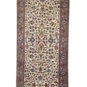 May include: An ivory-colored runner rug with an intricate floral pattern. The rug features a central design of stylized flowers and leaves in shades of red, blue, and green, framed by a detailed border. The rug measures approximately 3 feet wide.