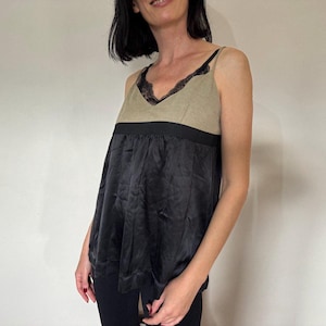 May include: A sleeveless top with a black lace trim at the neckline, a beige linen bodice, a black satin skirt, and a black waistband.