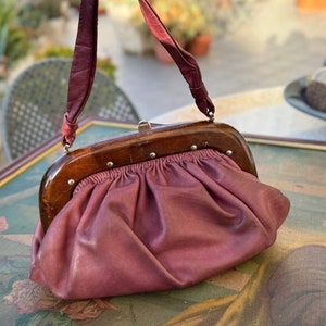 Burgunderfarbene Knödeltasche 1960er Jahre mit Holzverschluss. Puffige Tasche, elegante Clutch.