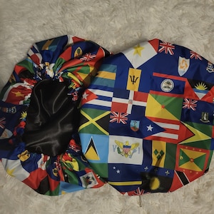 May include: Two satin sleep caps with a colorful pattern of flags from different countries. The caps are black on the inside and have a gathered elastic band.