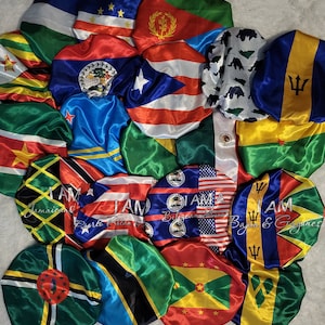 May include: A collection of 16 satin bonnets featuring various flags from different countries. The bonnets are arranged in a circle with the flags facing outwards. The flags include Jamaica, Puerto Rico, Belize, Guyana, Dominica, Trinidad and Tobago, Grenada, St. Vincent and the Grenadines, St. Lucia, Barbados, Antigua and Barbuda, St. Kitts and Nevis, Bahamas, and the United States.