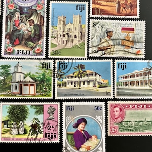 Puede incluir: Una colección de sellos postales antiguos de Fiji. Los sellos presentan varias imágenes, incluyendo una iglesia, un edificio, una escena navideña y un retrato de una mujer y un niño. Los sellos están en buen estado y tienen una variedad de denominaciones, incluyendo 8c, 30c, 45c, 1c, 2c, 50c y 87c.