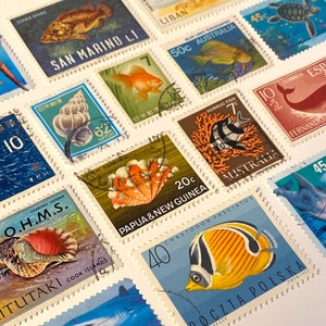 Puede incluir: Una colección de sellos postales coloridos que representan diversas criaturas marinas, incluyendo peces, conchas y una ballena. Los sellos son de diferentes países, incluyendo Australia, Japón, España y Papúa Nueva Guinea. Los sellos están en buen estado y tienen una variedad de diseños.