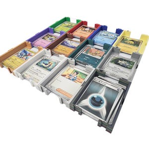 May include: A multi-colored card organizer filled with various trading cards. The organizer has multiple compartments in shades of green, red, blue, and white. The cards feature colorful illustrations and text, showcasing a variety of characters and designs.