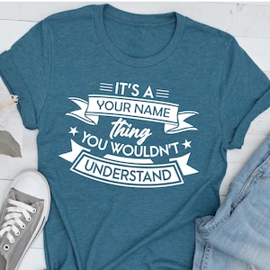 Puede incluir: Camiseta azul turquesa con texto blanco que dice "Es una cosa de [Tu nombre] que no entender&iacute;as".
