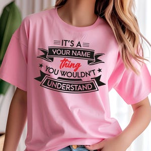 Puede incluir: Camiseta rosa con un gr&aacute;fico negro y rojo que dice "Es una cosa de [Tu nombre] que no entender&iacute;as."