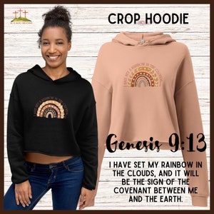 May include: A black and peach crop hoodie with a rainbow graphic and the text "I have set a rainbow in the clouds." The hoodie also features the text "Genesis 9:13" and a longer description of the verse.