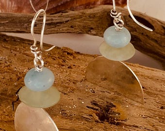 May include: A pair of silver earrings with a crescent moon shape and two stacked light blue and green stones.
